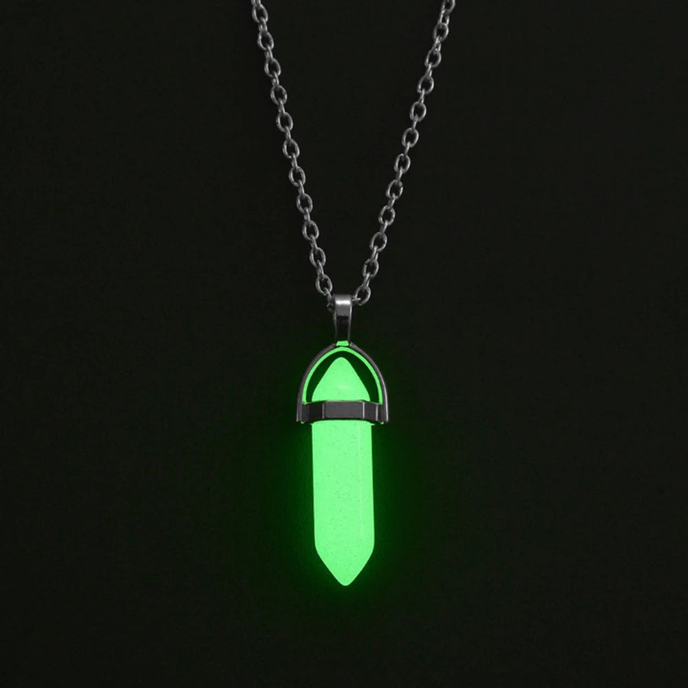 Glowing green pendant on a chain against a black background