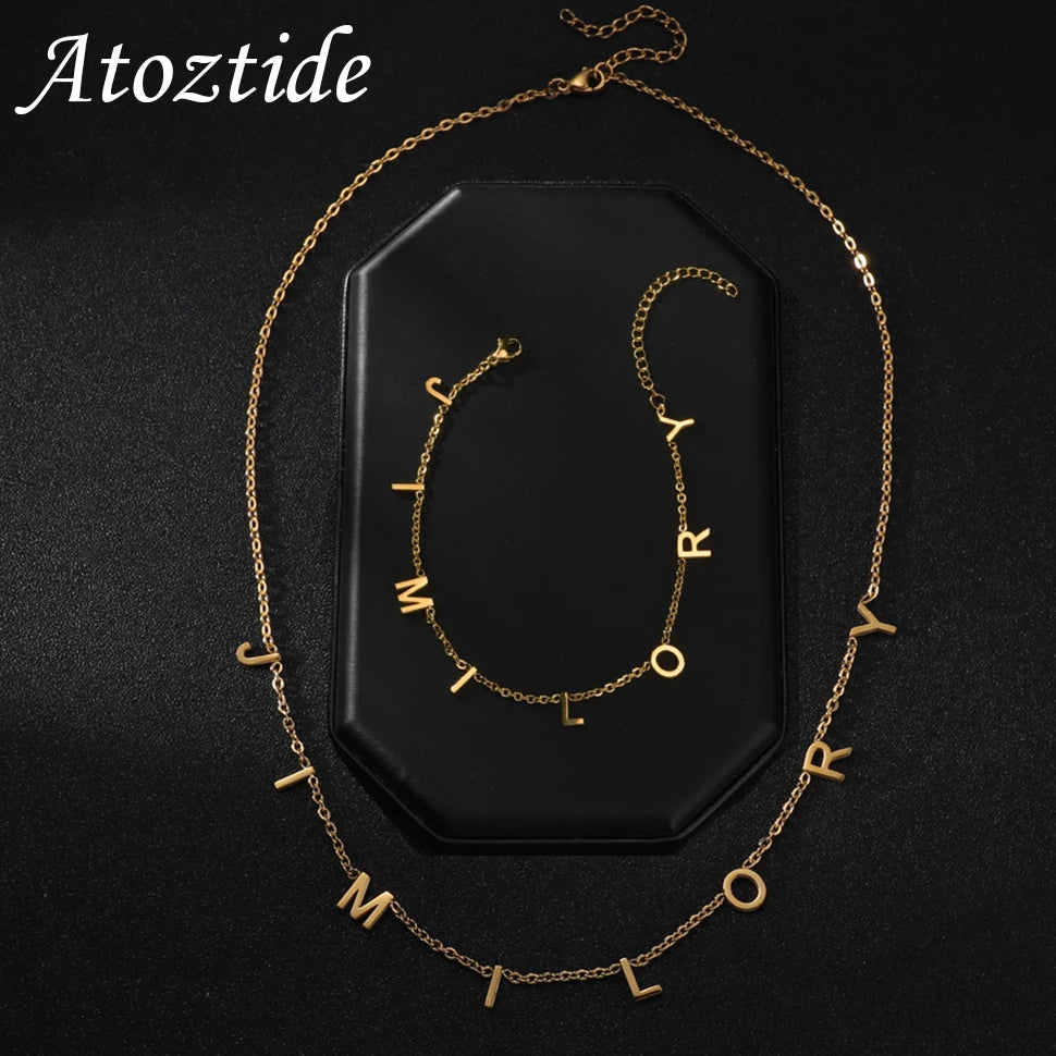 Atoztide Custom Names bracelet necklaces set featuring gold zircon letters on a stylish black background.