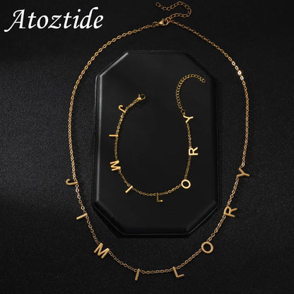 Atoztide Custom Names bracelet necklaces set featuring gold zircon letters on a stylish black background.