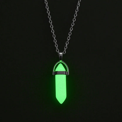 Glowing green pendant on a chain against a black background