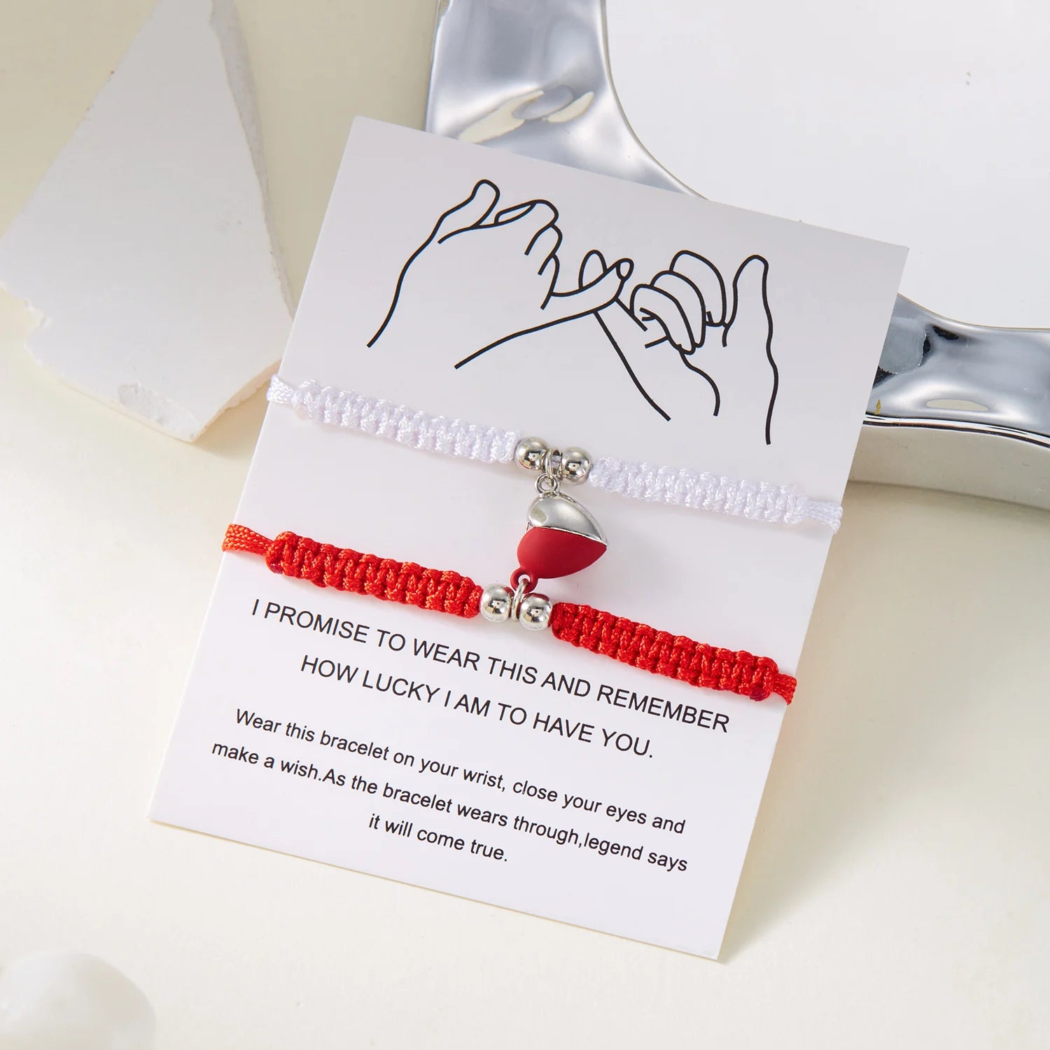 Red and white bracelet with a heart charm on a card with text, on a light background