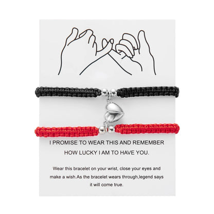 Black and red braided bracelets with a silver heart charm on a white card with text.