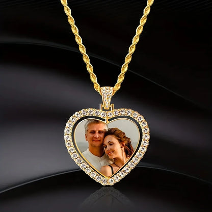 Heart-shaped gold pendant with a photo of a couple on a dark background