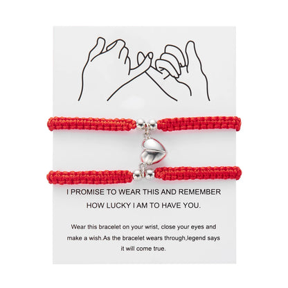 Red bracelet with a heart charm on a white card with text